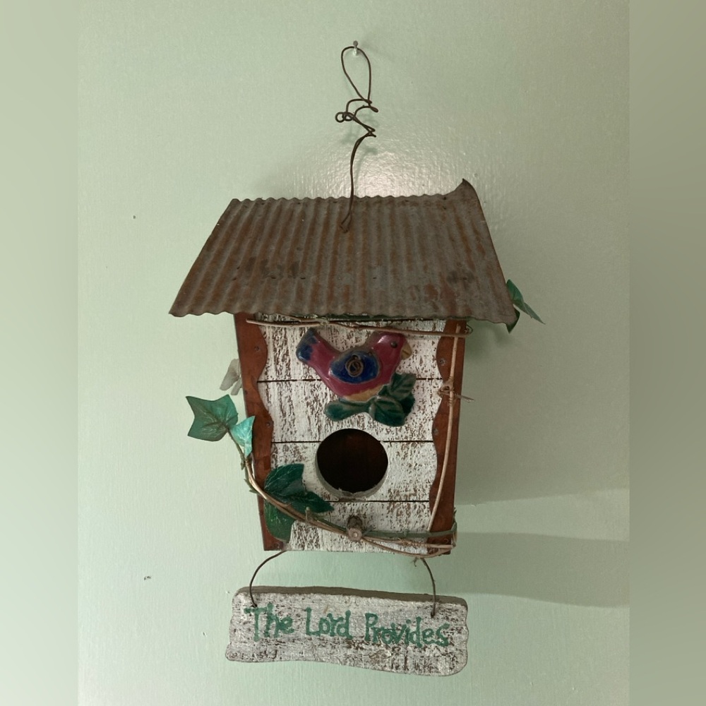 Decorated birdhouse which is made of wood and metal,with a ceramicbird figurine